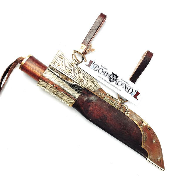 In sheath Rus Viking Damascus Knife #56A is a replica Viking Knife with decorated Sheath and features Norse decorative motifs carved in the bone handle accented with brass, and a Damascus blade that is sturdy and beautiful. The Brass decorated vegetable tanned sheath is a beauty to behold.