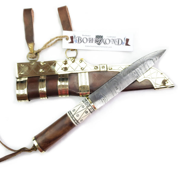 Rus Viking Damascus Knife #56A is a replica Viking Knife with decorated Sheath and features Norse decorative motifs carved in the bone handle accented with brass, and a Damascus blade that is sturdy and beautiful.