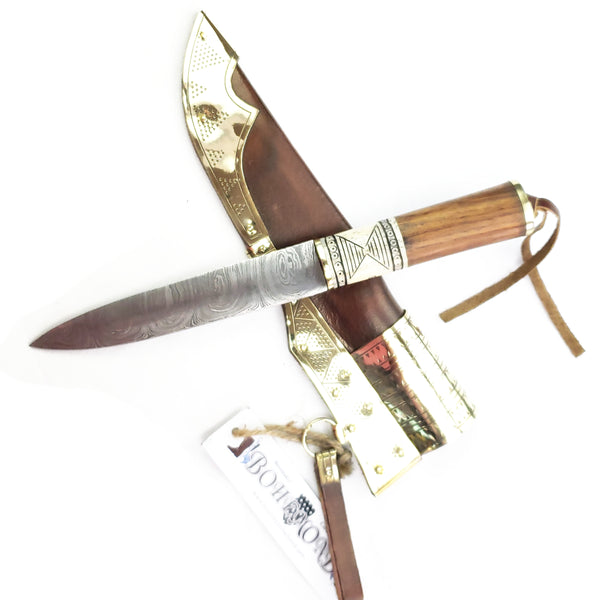 Blade across Rus Viking Damascus Knife #56D is a replica Viking Knife with decorated veg tanned with brass decorations Sheath and features Norse decorative motifs carved in the bone handle accented with brass, and a Damascus blade that is sturdy